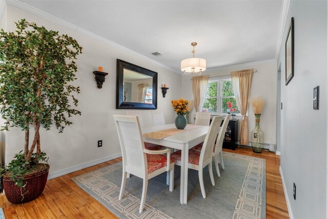 dining space featuring an inviting chandelier, visible vents, crown molding, baseboards, and light wood-style floors