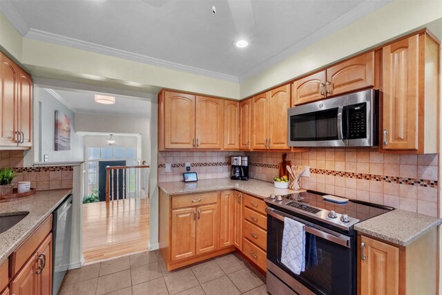 kitchen featuring light tile patterned floors, appliances with stainless steel finishes, ornamental molding, and light stone counters