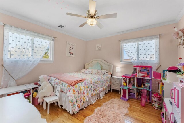 bedroom with multiple windows, wood finished floors, and visible vents