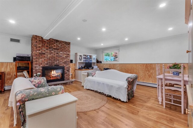 bedroom featuring crown molding, beam ceiling, a fireplace, light wood-style floors, and visible vents