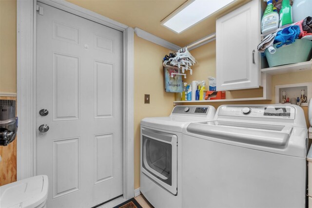 washroom featuring cabinet space and separate washer and dryer