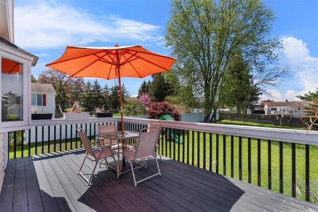wooden deck featuring fence, a yard, and outdoor dining space