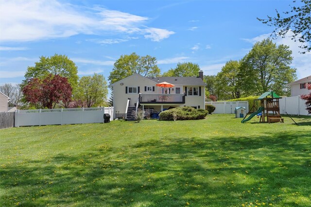 back of property featuring stairs, a wooden deck, a fenced backyard, a chimney, and a playground