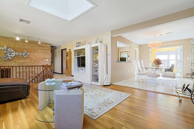living area featuring visible vents, baseboards, wood finished floors, and track lighting