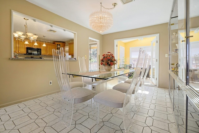 dining area featuring an inviting chandelier, baseboards, and light tile patterned floors