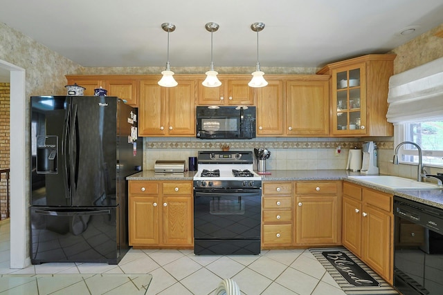 kitchen featuring glass insert cabinets, light tile patterned floors, a sink, backsplash, and black appliances