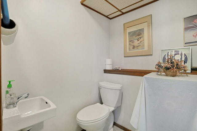 bathroom featuring baseboards, a sink, and toilet