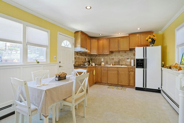kitchen featuring crown molding, a sink, white fridge with ice dispenser, and a baseboard radiator