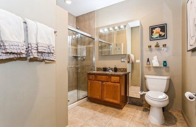 bathroom featuring a shower stall, toilet, tile patterned flooring, and vanity