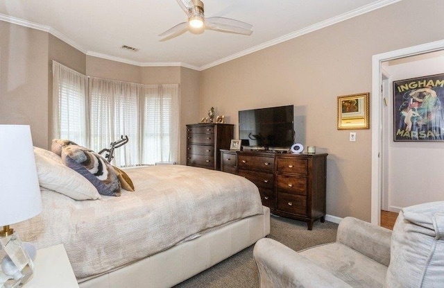 carpeted bedroom featuring visible vents, crown molding, baseboards, and ceiling fan