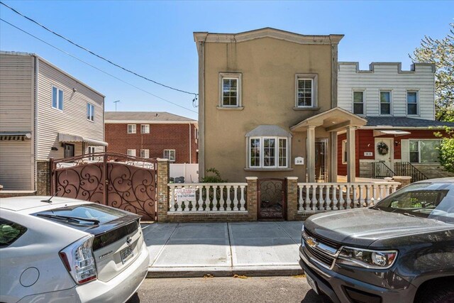 21-09 48th St, Astoria, NY 11105 - view of front of home featuring a gate, a fenced front yard, and stucco siding
