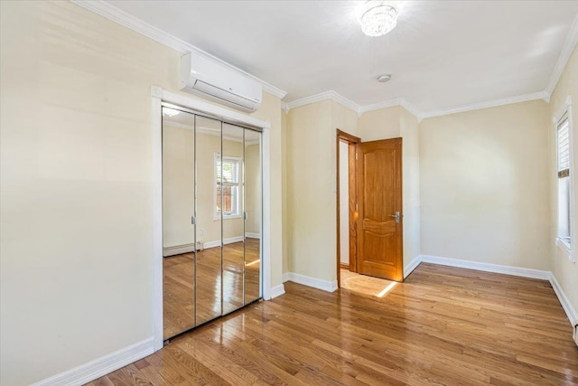 21-09 48th St, Astoria, NY 11105 - unfurnished bedroom featuring baseboard heating, an AC wall unit, baseboards, wood finished floors, and a closet