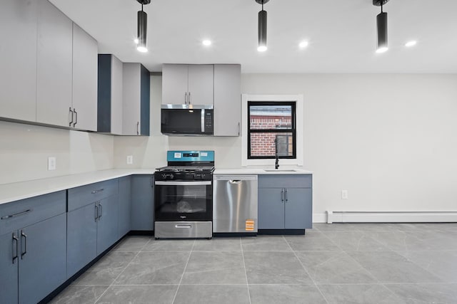 kitchen featuring a sink, baseboard heating, pendant lighting, light countertops, and appliances with stainless steel finishes