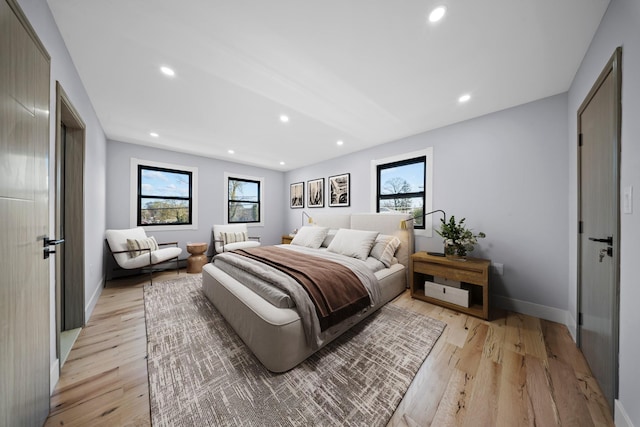 bedroom with baseboards, recessed lighting, and light wood-style flooring