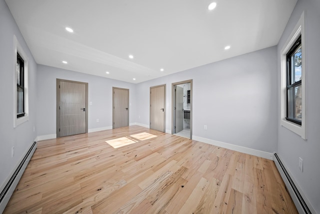 unfurnished bedroom with light wood finished floors, baseboard heating, baseboards, and recessed lighting
