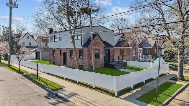 view of front of house featuring brick siding, a residential view, and a fenced front yard