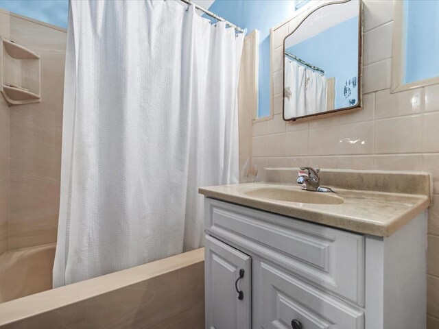 bathroom with tile walls, vanity, and tasteful backsplash
