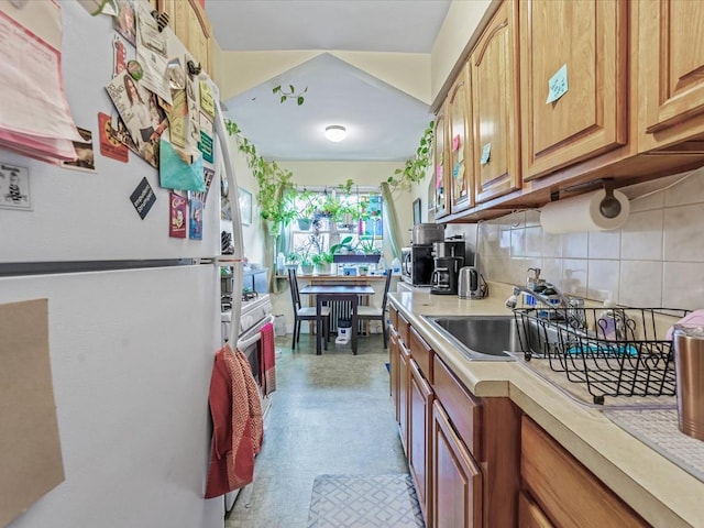 kitchen with a sink, tasteful backsplash, white appliances, brown cabinetry, and light countertops