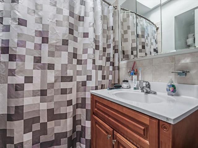 full bathroom with backsplash, vanity, and tile walls