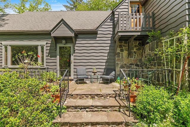 1391 Hunterbrook Rd, Yorktown Heights, NY 10598 - doorway to property featuring a patio, roof with shingles, a balcony, and stone siding