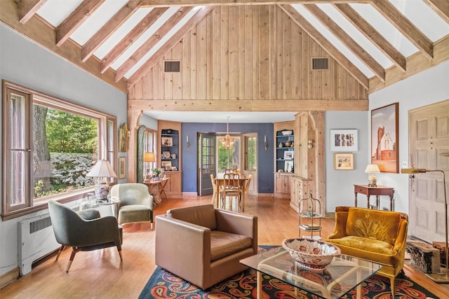 1391 Hunterbrook Rd, Yorktown Heights, NY 10598 - living room featuring radiator heating unit, wood finished floors, high vaulted ceiling, healthy amount of natural light, and wooden walls