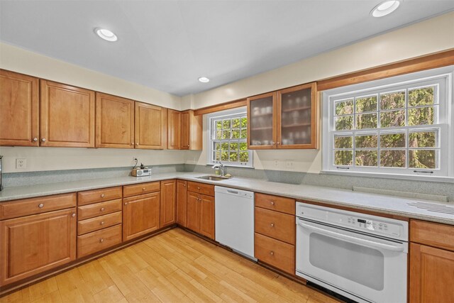 1391 Hunterbrook Rd, Yorktown Heights, NY 10598 - kitchen with white appliances, a sink, light wood-type flooring, light countertops, and glass insert cabinets