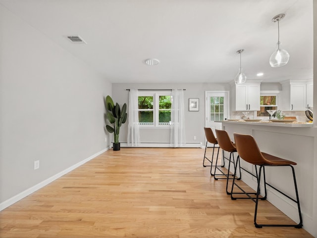 31 Pennsylvania Ave, Valley Cottage, NY 10989 - kitchen featuring a kitchen breakfast bar, white cabinetry, baseboards, and light wood-style flooring