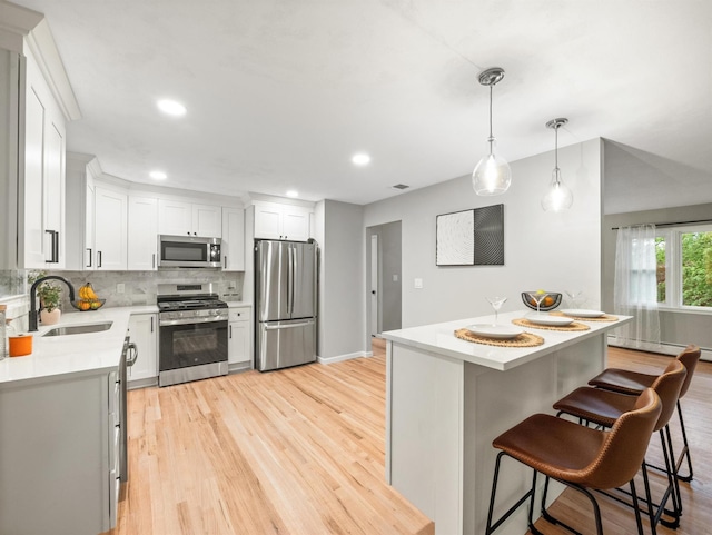 31 Pennsylvania Ave, Valley Cottage, NY 10989 - kitchen featuring stainless steel appliances, a sink, light countertops, light wood-style flooring, and backsplash