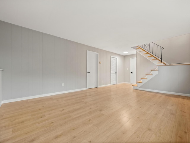 31 Pennsylvania Ave, Valley Cottage, NY 10989 - unfurnished living room featuring stairs, light wood-style floors, baseboards, and wooden walls