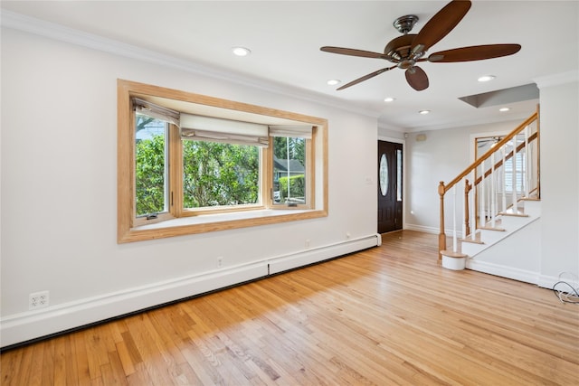 entrance foyer with stairway, wood finished floors, a baseboard heating unit, ceiling fan, and ornamental molding