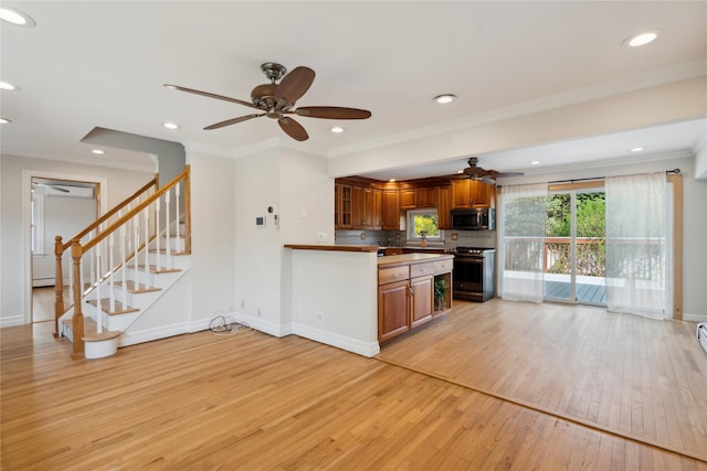 kitchen featuring light wood-type flooring, stainless steel appliances, baseboards, and ceiling fan