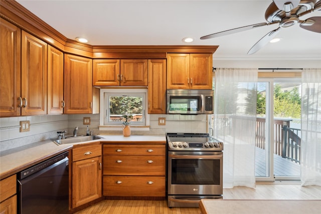 kitchen featuring plenty of natural light, a ceiling fan, stainless steel appliances, and a sink