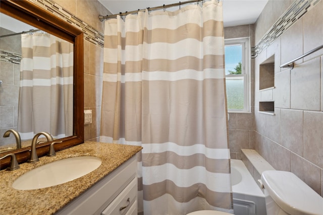 full bathroom featuring tile walls, toilet, vanity, and shower / bath combination with curtain