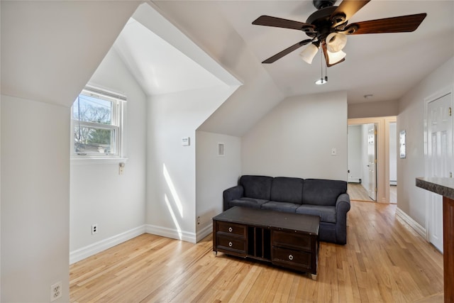 living room featuring light wood-type flooring, baseboards, visible vents, lofted ceiling, and a ceiling fan