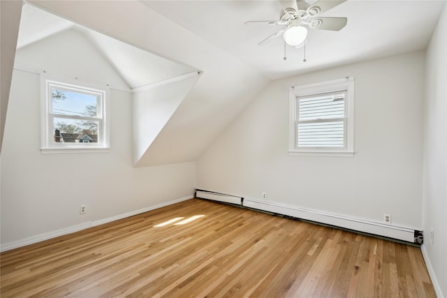 bonus room featuring lofted ceiling, light wood-style flooring, a baseboard radiator, and a ceiling fan