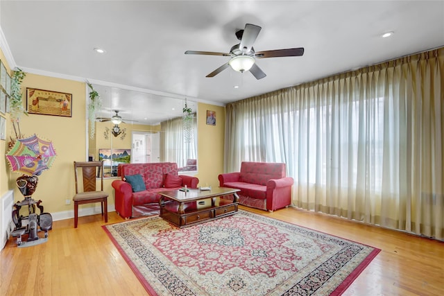 living area featuring recessed lighting, a ceiling fan, crown molding, baseboards, and light wood-style flooring