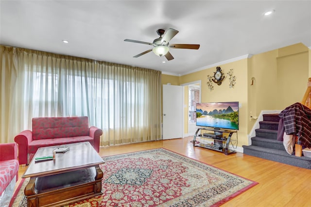 living area with recessed lighting, wood finished floors, ornamental molding, and ceiling fan