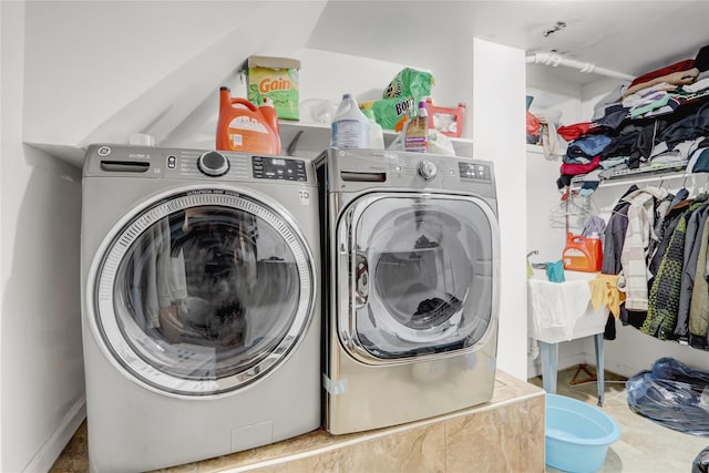 washroom featuring baseboards, washer and clothes dryer, and laundry area