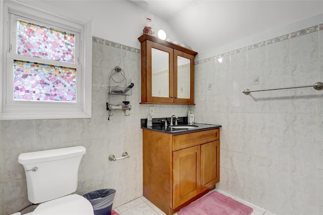 bathroom featuring tile walls, lofted ceiling, and toilet
