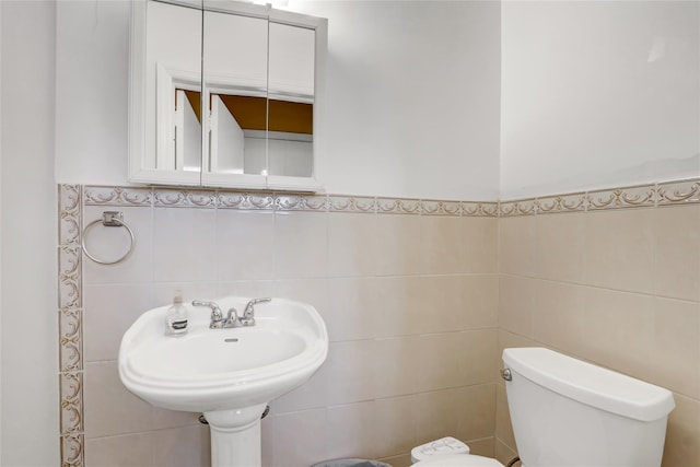 half bathroom with tile walls and toilet