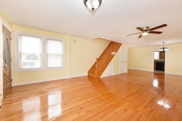 224-40 Fairbury Ave, Queens Village, NY 11428 - unfurnished living room featuring stairway, light wood finished floors, baseboards, and ceiling fan with notable chandelier