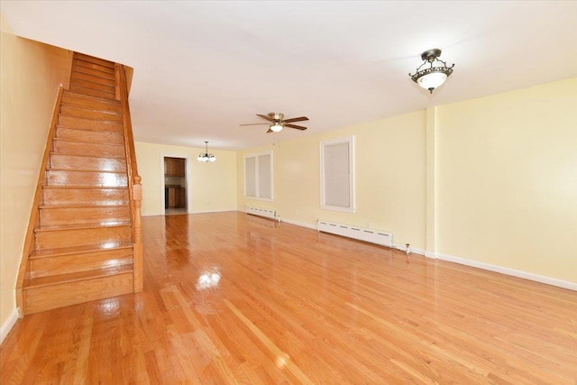 224-40 Fairbury Ave, Queens Village, NY 11428 - interior space with a baseboard heating unit, light wood-style flooring, ceiling fan with notable chandelier, stairway, and a baseboard radiator