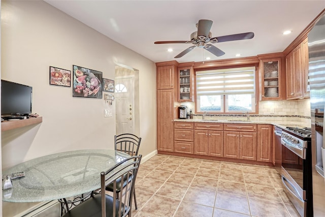 176 Kearsing Pkwy, Monsey, NY 10952 - kitchen with stainless steel range with gas stovetop, a sink, decorative backsplash, ceiling fan, and light stone counters
