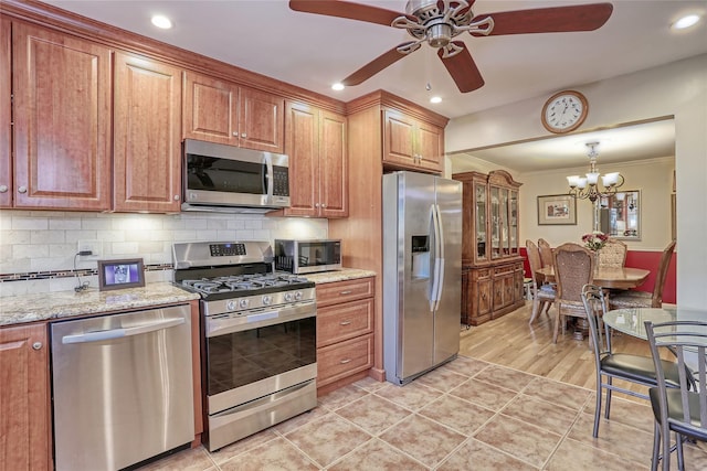 176 Kearsing Pkwy, Monsey, NY 10952 - kitchen with appliances with stainless steel finishes, ceiling fan, brown cabinetry, a chandelier, and crown molding
