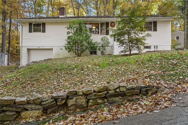 view of front of property with an attached garage and a chimney