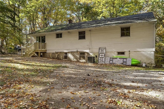 back of property with central AC and a chimney