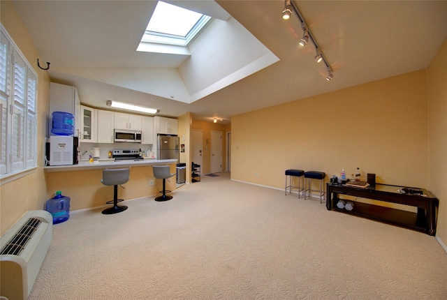 1337 Broadway Unit C22, Hewlett, NY 11557 - kitchen featuring light colored carpet, glass insert cabinets, appliances with stainless steel finishes, a kitchen bar, and white cabinetry