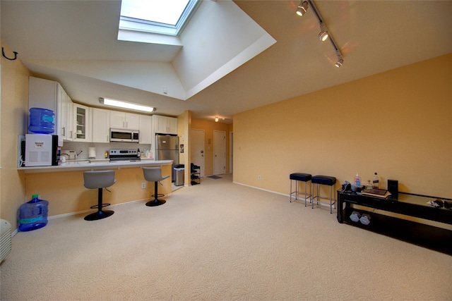 1337 Broadway Unit C22, Hewlett, NY 11557 - kitchen featuring light colored carpet, glass insert cabinets, stainless steel appliances, a kitchen bar, and rail lighting