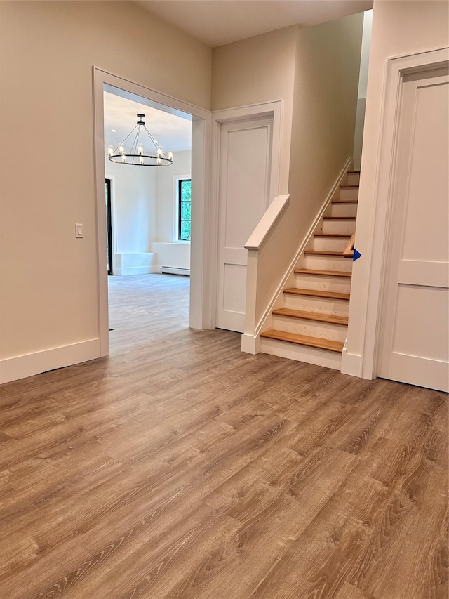 9 Ogrady Ct, Orangeburg, NY 10962 - staircase with a chandelier, baseboard heating, wood finished floors, and baseboards