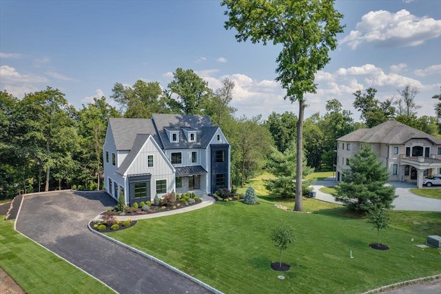 9 Ogrady Ct, Orangeburg, NY 10962 - view of front of house featuring an attached garage, driveway, board and batten siding, a front lawn, and a standing seam roof
